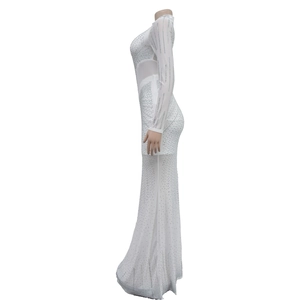 Dettaglio di abito lungo bianco in mesh con strass e maniche lunghe su manichino