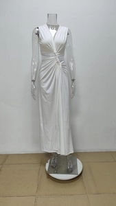 Detailed view of the deep V-neckline with waist cutout and twist knot on white maxi dress