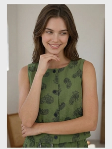 Detail of green paisley print linen vest featuring classic black buttons and textured fabric