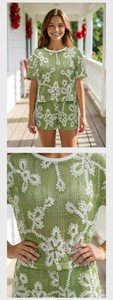 Dettaglio della trama floreale all'uncinetto verde e del tessuto a maglia del set estivo