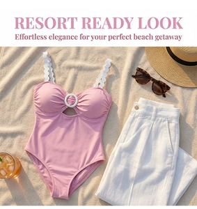 Pink one-piece swimsuit with scalloped straps and ring cutout detail on beach mat