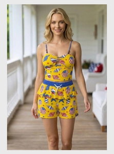 Detail of yellow two-piece summer set featuring ocean prints and American flag motifs