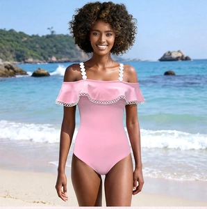 Dettaglio del costume intero rosa con scollo a balze e spalline decorative con anelli bianchi