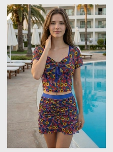 Detail view of floral print crop top and ruffled mini skirt set by a sunny resort pool