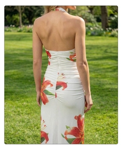 Detail of ruched back and orange lily floral print on a white halter neck dress