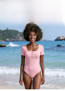 Detail of pink one-piece swimsuit featuring gold star buckles and square neckline design