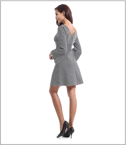 Detail view of houndstooth dress featuring stylish bell sleeves and backless V-neck design