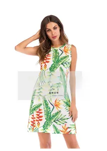 Détail d'une robe d'été sans manches avec imprimé floral et feuilles tropicales vertes