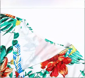 Dettaglio dello scollo a V con vivace stampa floreale di gigli su tessuto bianco