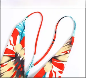 Close-up of tropical floral print bikini top with red base and thin neck straps