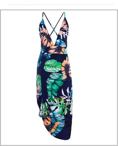 Detail view of the deep V-neck and tropical leaf print on this sexy backless maxi dress