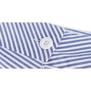 Détail du col d'une chemise à rayures bleues et blanches avec bouton et texture de tissu fine