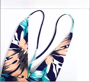 Close-up of V-neckline and adjustable spaghetti straps on tropical print swimsuit