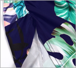 Detail of tropical plant print on navy blue dress with side slit and fine stitching