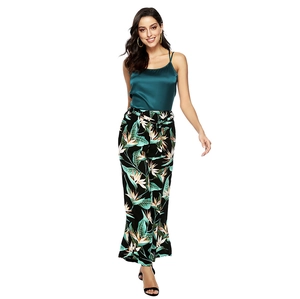 Detail of dark green satin camisole top and tropical floral print wide leg trousers