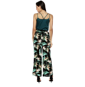Detail of cross-back satin camisole and tropical print wide-leg trousers on a model