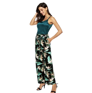 Detail view of dark green satin camisole and tropical print wide leg trousers set