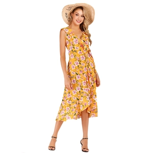 Détail de la robe mi-longue jaune fleurie à col en V avec volants et motifs de papillons