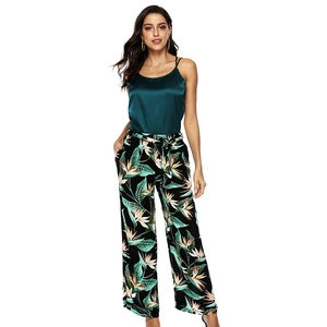 Women's two-piece set featuring a satin green camisole and tropical print wide leg pants