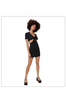 Detail van zwarte bodycon jurk met stijlvolle zij-uitsparingen en een knoopdetail voorop