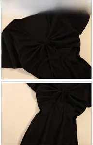Detail van zwarte geribbelde crop top met gedraaide knoop en uitsparingen aan de zijkant
