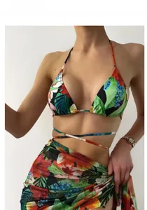 Detail view of a three-piece tropical floral bikini set with a matching sheer mesh sarong