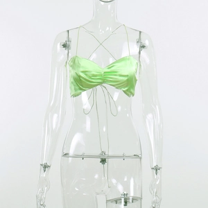 Detail of light green satin bralette featuring delicate ruching and thin tie straps