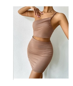 Detail of brown ribbed knit two-piece set featuring a one-shoulder top and mini skirt