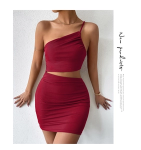 Detail of burgundy ribbed knit two-piece set featuring cutout waist and one-shoulder top