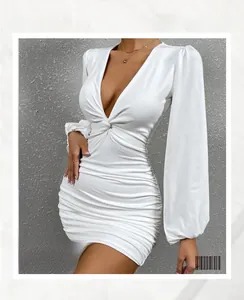Détail de robe blanche avec décolleté en V profond, manches lanternes et tissu froncé