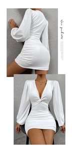 Détails du décolleté en V profond et de la robe blanche drapée à manches lanternes