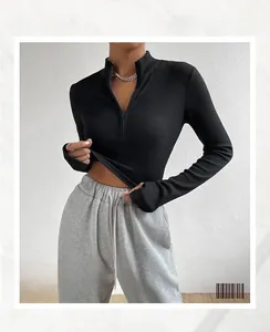 Close-up of the black ribbed knit fabric and metal zipper detail on the slim-fit top