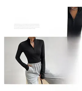 Detail of ribbed knit black long sleeve top featuring a functional half-zip stand collar