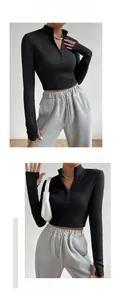 Detail of black ribbed knit crop top with quarter zip stand collar and thumbhole cuffs