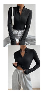 Close-up of black ribbed knit long sleeve shirt with a quarter zipper and stand collar