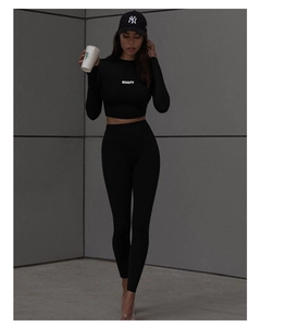 Detail of black sports set with cropped long sleeve top and white BEAUTY lettering print