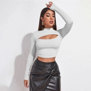 Dettaglio di un crop top bianco a collo alto e maniche lunghe con taglio sul petto alla moda
