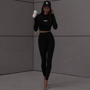 Women's black long sleeve crop top and high waist yoga pants set with BEAUTY text