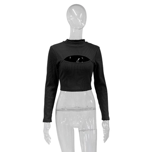 Dettaglio del crop top nero a costine con collo alto e apertura frontale sul petto