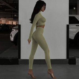 Olive green two-piece yoga set featuring a long sleeve crop top and high waist leggings