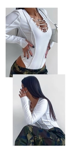 Détail d'un body blanc côtelé avec décolleté en V plongeant et design évidé à lacets