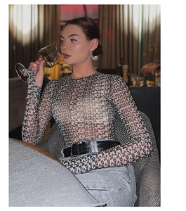 Detail of sheer mesh bodysuit featuring letter print and slim fit long sleeve design