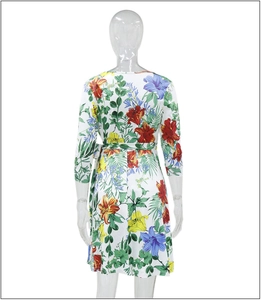 Rückansicht eines weißen V-Ausschnitt-Kleides mit roten und blauen Lilienprints auf Model