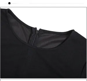 Close-up detail of the black dress featuring a round neckline and hidden back zipper