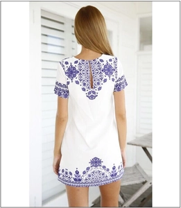 Detail view of the bohemian floral print and keyhole back closure on a white summer dress