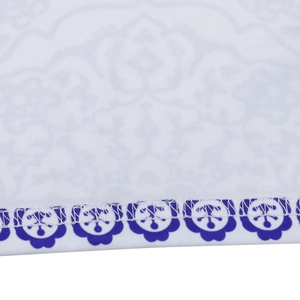 Detailed macro view of the ethnic print dress hem with precise blue floral stitching pattern