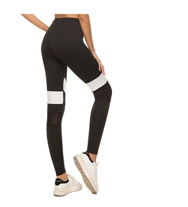 Detail view of high-waist yoga leggings with black and white color-blocking and mesh panels