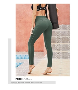 Detail view of high waisted yoga leggings in dark green with functional side pocket