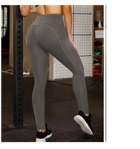 Detail view of high waist yoga leggings with functional side pockets in dark grey color