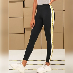 Women's high waist black yoga leggings featuring yellow LOVE letter print side stripe